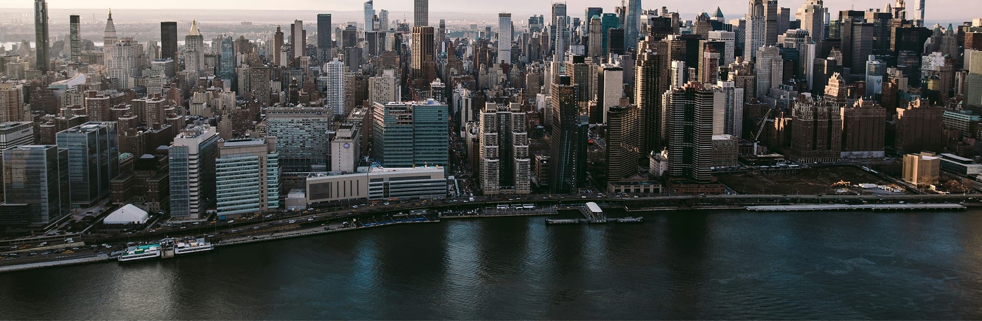Cityscape view of New York City next to a body of water.